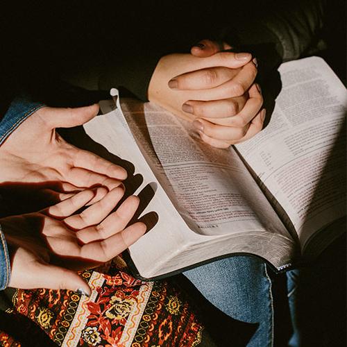 Two students sharing a Bible